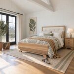 Diagonal angled room view showing the left side of a contemporary upholstered bed with flared feet, in a vaulted bedroom.