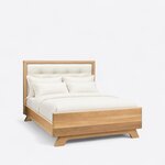 Diagonal angled view showing the right side of a contemporary upholstered bed, with a tufted headboard and flared feet.