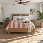 Front room view of a minimalist panel bed with square posts and a low footboard, in a coastal bedroom with a ceiling fan.