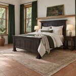 Diagonal angled room view showing the left side of a Shaker panel bed with dentil molding, in a terracotta-tiled bedroom.