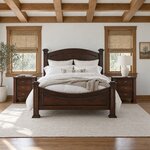 Front room view of a traditional poster bed with capped square posts, in a white bedroom with a beamed ceiling.
