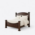 Diagonal angled view showing the left side of a traditional poster bed, with an arched headboard and a curved footboard.