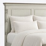 Headboard close-up of a traditional panel bed, showing the crown-molded cornice, recessed panels and a turned column.