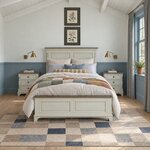 Front room view of a traditional panel bed with a crown-molded headboard, in a bedroom with blue beadboard wainscoting.