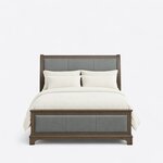 Front view of an upholstered sleigh bed, showing three-section leather panels on the headboard and the low footboard.