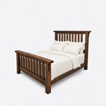 Diagonal angled view showing the left side of a rustic slat bed, with square posts and a slatted headboard and footboard.