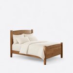 Diagonal angled view showing the right side of a contemporary short post bed, with arched solid panels and tapered legs.