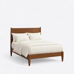 Diagonal angled view showing the right side of a modern panel bed, with a flat-panel headboard and tapered legs.