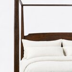 Headboard close-up of a classic canopy bed, showing a tapered post, a canopy rail joint and the notched headboard corner.