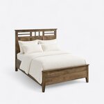 High angled view of a contemporary panel bed, looking down on the lattice headboard, a side rail and the low footboard.