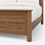Footboard close-up of a transitional panel bed, showing the overhanging cap rail, a square corner post and recessed panels.