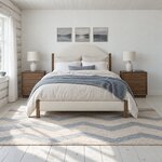 Front room view of a modern upholstered bed with an arched upholstered headboard, in a whitewashed log cabin bedroom.