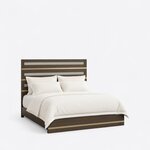 Diagonal angled view showing the right side of a modern panel bed, with a metal-banded headboard and a low footboard.