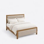 High angled view of a contemporary upholstered bed, looking down on the framed panels, plain side rails and square legs.