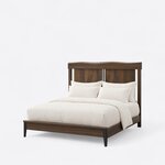 Diagonal angled view showing the left side of a contemporary panel bed, with a wavy-top headboard and tapered foot legs.