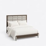 High angled view of a modern upholstered bed, looking down on the tall framed grid headboard and the low capped footboard.