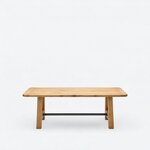 Front view of a farmhouse trestle table, with a long top on matching end supports joined by a low metal stretcher.