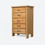 Diagonal angled view showing the left side of a farmhouse chest of drawers, with five drawers and a framed side panel.