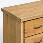 Top corner close-up of a farmhouse chest of drawers, with a square-edged slab top overhanging a broad corner post.