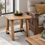 Diagonal angled room view showing the right side of a rustic coffee table with a metal stretcher, in a brick-walled loft.