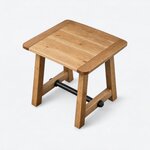 High angled view of a rustic coffee table, showing a near-square plank top with broad end pieces on opposing sides.