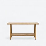 Front view of a farmhouse console table, with a long overhanging top and a lower shelf between paired legs.