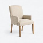 Diagonal angled view showing the right side of an upholstered armchair, with a tall back, padded arms and tapered legs.