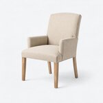 Diagonal angled view showing the left side of an upholstered armchair, with a tall back, padded arms and tapered legs.