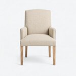 Front view of an upholstered armchair, with a tall back, a broad seat and matching low arms above tapered legs.