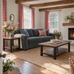 Diagonal angled room view showing the right side of an industrial end table with a low shelf, in a living room with beams.