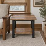 Front room view of an industrial end table with a low open shelf, in a living room with wood window trim.