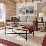 Diagonal angled room view showing the left side of an industrial coffee table with a metal frame, in a cabin living room.
