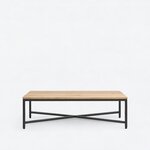 Front view of an industrial coffee table, with a long thin top and a symmetrical metal frame on square legs.
