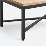 Leg close-up of an industrial coffee table, with a square metal leg, a round foot glide and a low diagonal stretcher.